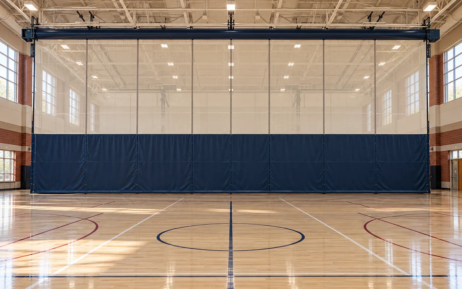 Navy and cream center-roll gym divider curtain in a bright fieldhouse